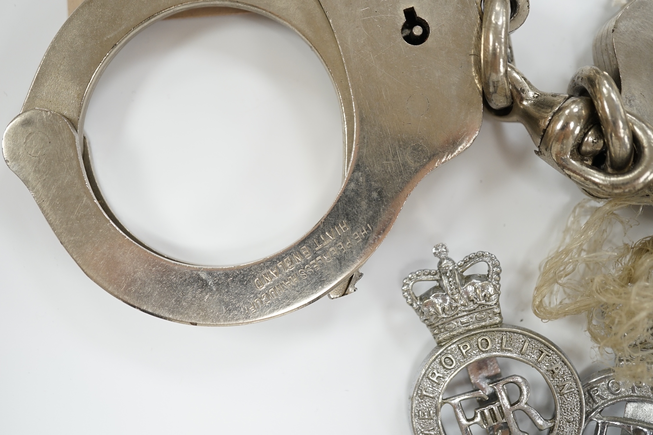 Three handcuffs, two with keys and two Metropolitan Police badges